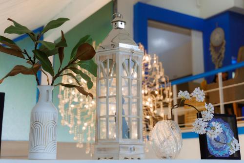 a glass lantern sitting on a table next to a vase at Sheva Om in Ban Wat Pho Thong