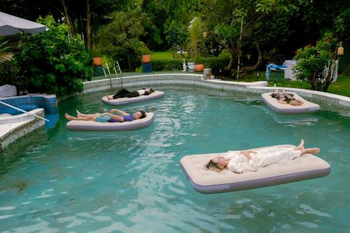 a group of people laying on rafts in a pool at Sheva Om in Ban Wat Pho Thong