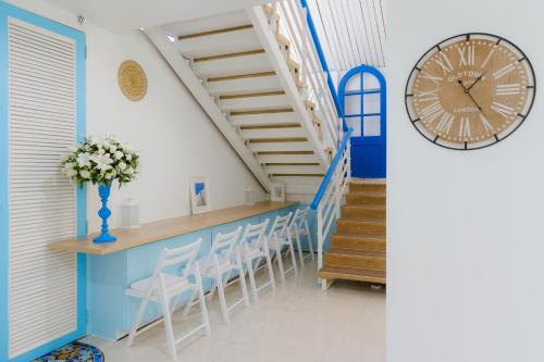 a staircase with a table and chairs and a clock at Sheva Om in Ban Wat Pho Thong