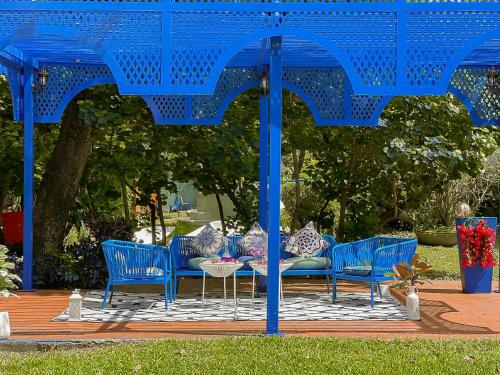 a group of blue chairs and a table under a blue umbrella at Sheva Om in Ban Wat Pho Thong