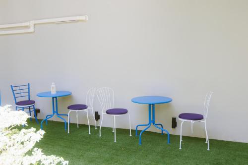 a group of tables and chairs with grass at Sheva Om in Ban Wat Pho Thong