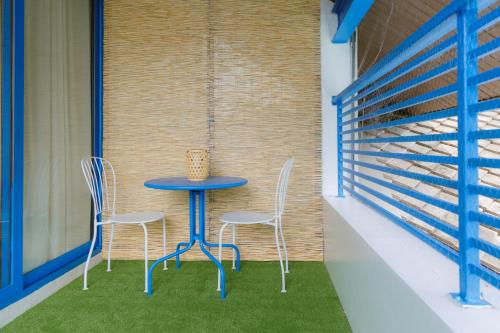 a table and chairs on a balcony with grass at Sheva Om in Ban Wat Pho Thong