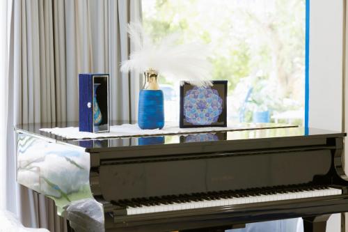 a piano with two vases and a feather on it at Sheva Om in Ban Wat Pho Thong