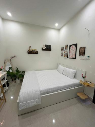 a white bedroom with a large bed with white sheets at Danang's house in Da Nang