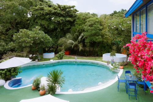 a swimming pool with chairs and flowers in a yard at Sheva Om in Ban Wat Pho Thong