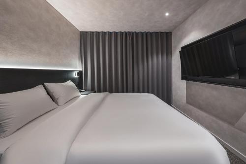 a bedroom with a large white bed in it at GOYOO INN & homes in Seoul