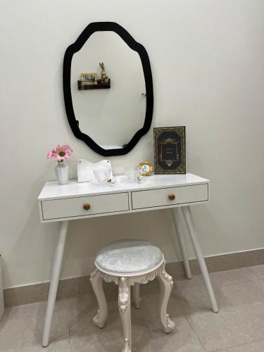 a white dressing table with a stool and a mirror at Danang's house in Da Nang