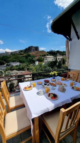 a table with plates of food on a balcony at Çelo's house Gjirokaster in Gjirokastër
