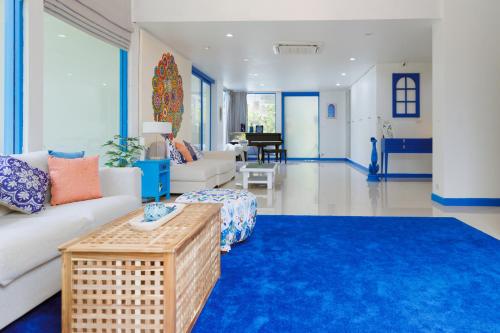 a living room with a white couch and a blue rug at Sheva Om in Ban Wat Pho Thong