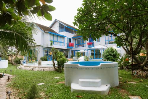 a bath tub sitting in the yard of a house at Sheva Om in Ban Wat Pho Thong