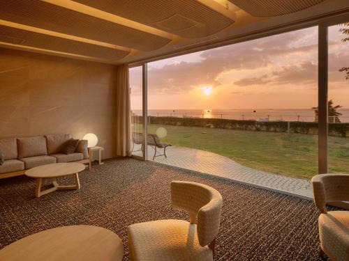 a living room with a view of the ocean at KAMENOI HOTEL Awajishima in Awaji