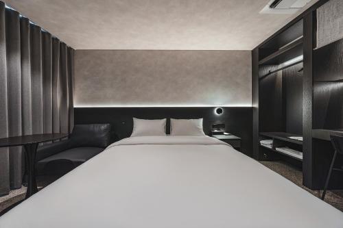 a bedroom with a large white bed and a couch at GOYOO INN & homes in Seoul