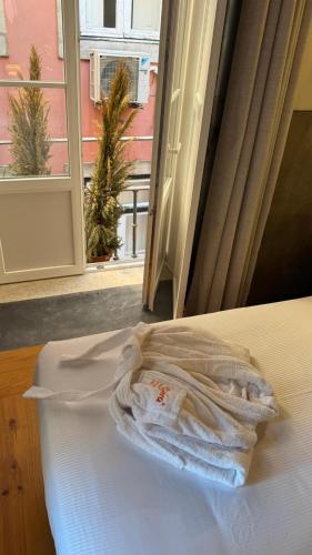 a white towel sitting on a bed with a window at Inspira Santos Boutique Hotel in Lisbon
