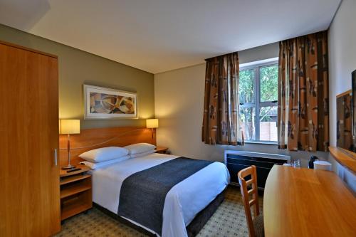 a hotel room with a bed and a desk at Road Lodge Sandton in Johannesburg