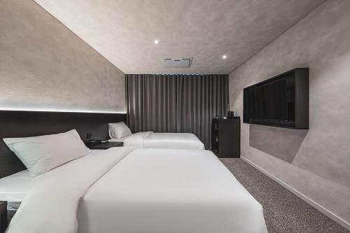 a bedroom with two beds and a flat screen tv at GOYOO INN & homes in Seoul