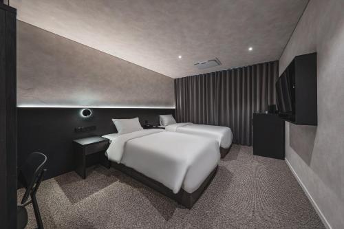 a bedroom with a large white bed and a television at GOYOO INN & homes in Seoul