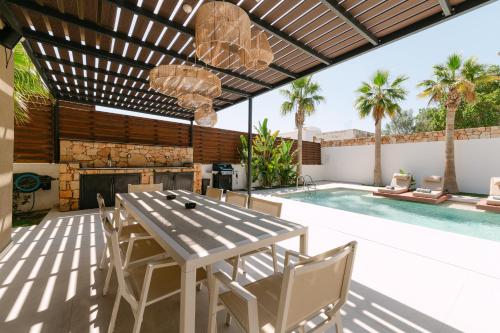 a patio with a table and chairs and a swimming pool at STALèA Luxury Villa in Pefki Rhodes