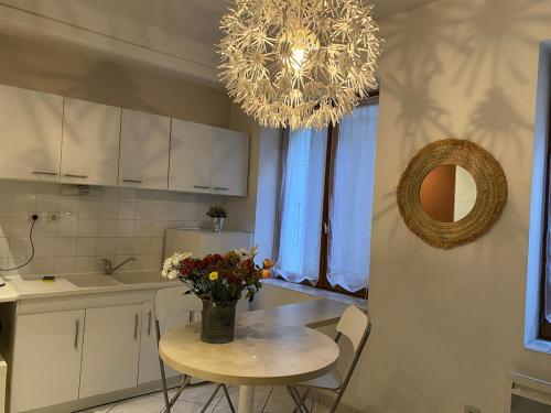 een keuken met een tafel met daarop een vaas met bloemen bij Oasis - City Center in Annecy