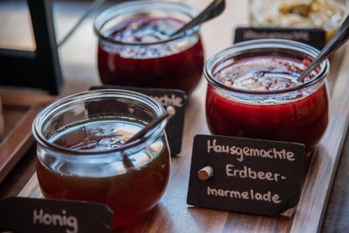 three jars of jam on a wooden table with labels at Gutshofhotel Winkler Bräu in Lengenfeld