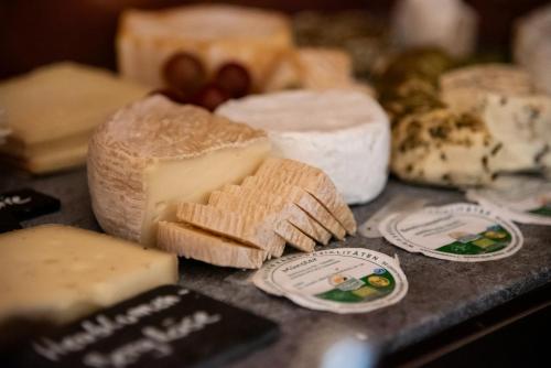 a bunch of different types of cheese on a table at Gutshofhotel Winkler Bräu in Lengenfeld