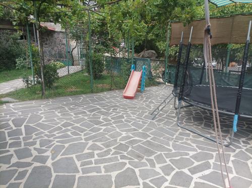 a playground with a red slide and a swing set at Cozy Corner in Borjomi