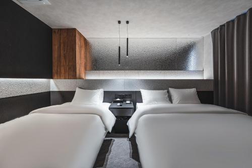 two twin beds in a room with at GOYOO INN & homes in Seoul