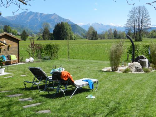 two chairs sitting in the grass in a field at Gasthof Wiesenhof in Strobl