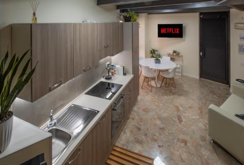 - une cuisine avec un évier et une table dans une chambre dans l'établissement Loft32Pavia, moderno appartamento di 60mq in zona stazione, à Pavia