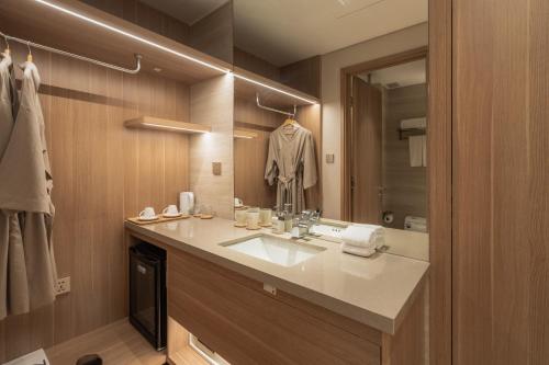 a bathroom with a sink and a mirror at Nola Hotel in Ho Chi Minh City