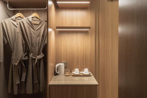 a bathroom with a closet with a robe and shoes at Nola Hotel in Ho Chi Minh City