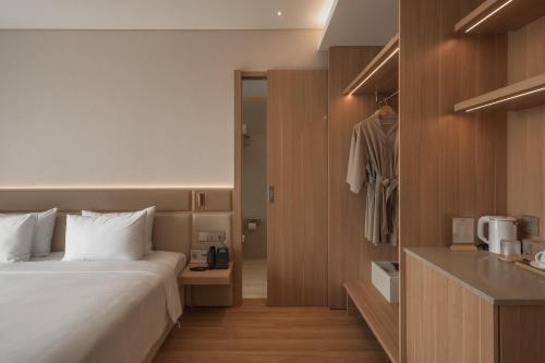 a hotel room with a bed and a closet at Nola Hotel in Ho Chi Minh City