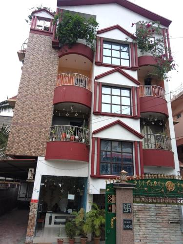 a tall building with red windows and potted plants at Hotel Suvika Inn in Guwahati