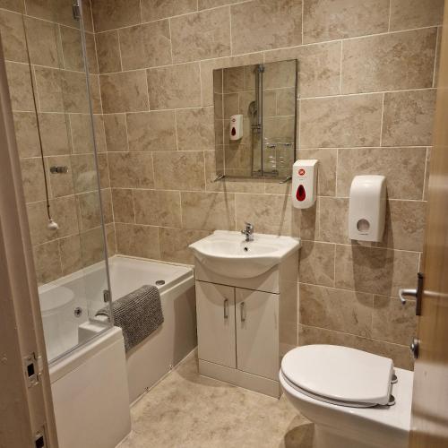 a bathroom with a toilet and a sink and a shower at The Dorchester Hotel & serviced apartments in Hull