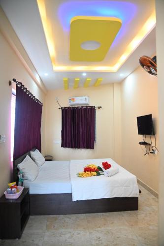 ein Hotelzimmer mit einem Bett mit Blumen darauf in der Unterkunft Sheethal comforts-Chamundi hill view in Mysore