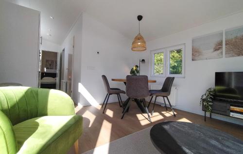 a living room with a green couch and a table at Lovely Home In Heinkenszand With Heated Swimming Pool in Heinkensand