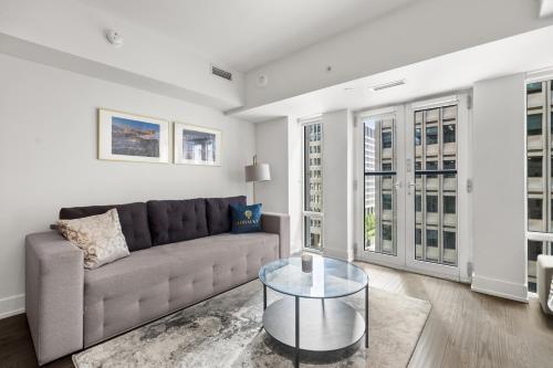 a living room with a couch and a glass table at Modern 1Bd & Den in Downtown Toronto in Toronto