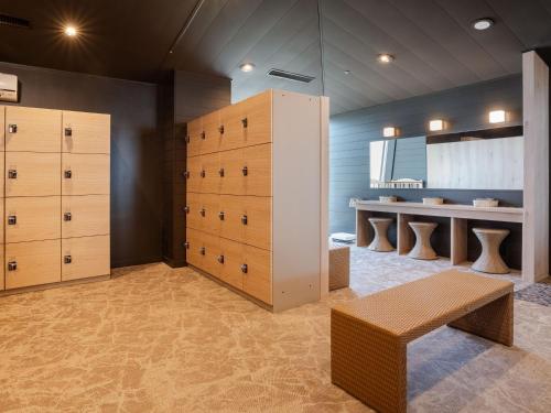 a locker room with wooden drawers and a bench at KAMENOI HOTEL Awajishima in Awaji