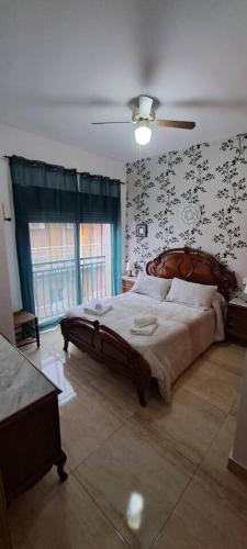 a bedroom with a large bed with a wooden headboard at Apartamento Calle Real in Martos