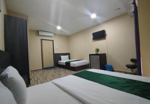 a hotel room with two beds and a television at Fast Hotel Idaman Near To IIUM KL in Kuala Lumpur