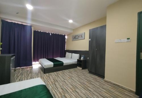 a hotel room with a bed and purple curtains at Fast Hotel Idaman Near To IIUM KL in Kuala Lumpur