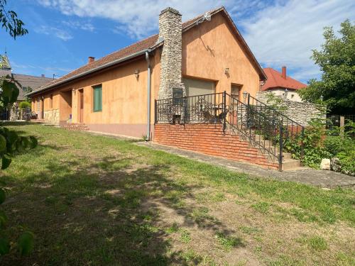 a brick house with a brick chimney and a yard at GreenPark Candy Apartments with Large Garden Close to Tokaj in Bekecs