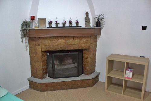 a living room with a brick fireplace with a mantle at Aμvrosia Avramio Village - Fireplace, Free WiFi, Pet Friendly in Avramión