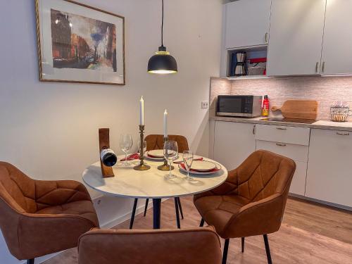 a dining room table with three chairs and a table with candles at Secret Home mit Seeblick Ruppinersee in Neuruppin