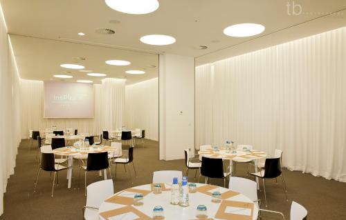 a conference room with tables and chairs and a screen at Inspira Liberdade Boutique Hotel in Lisbon