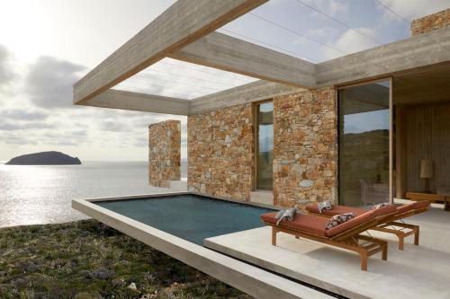 a house with a swimming pool next to the ocean at Perma Serifos in Serifos Chora