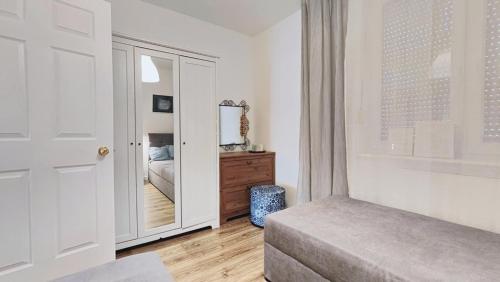 a bedroom with a mirror and a bed and a dresser at Apartament Bursztynowy Jantar 2 pokojowy z ogrodzonym tarasem przy nadmorskim lesie in Jantar