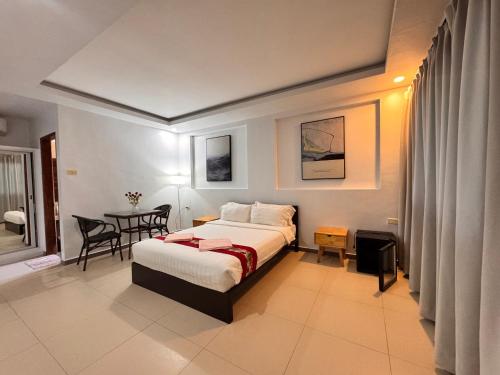a bedroom with a bed and a table in it at Azahar Resort Panglao powered by Cocotel in Panglao