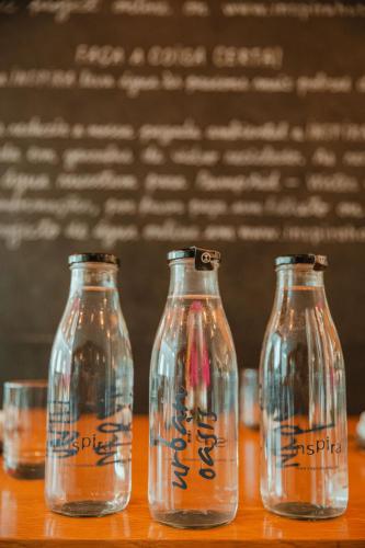three empty glass bottles sitting on a table at Inspira Liberdade Boutique Hotel in Lisbon