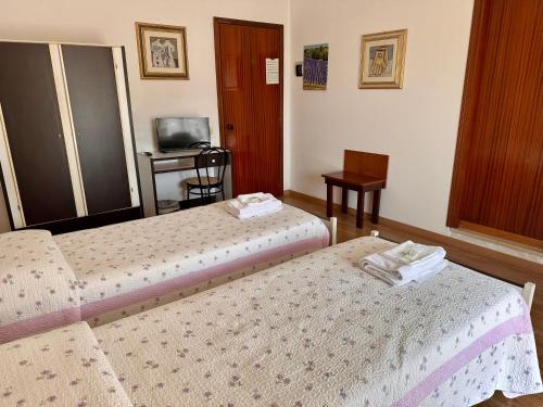 a hotel room with two beds and a television at Asso di Coppe in Deruta