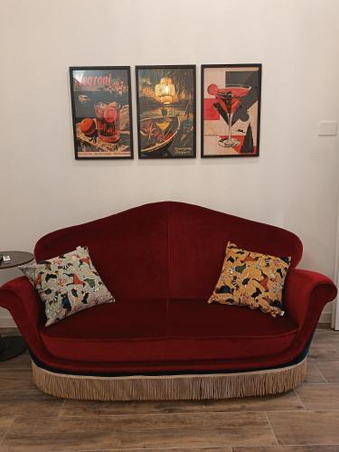 a red couch in a living room with four framed posters at The Quarters in Cagliari